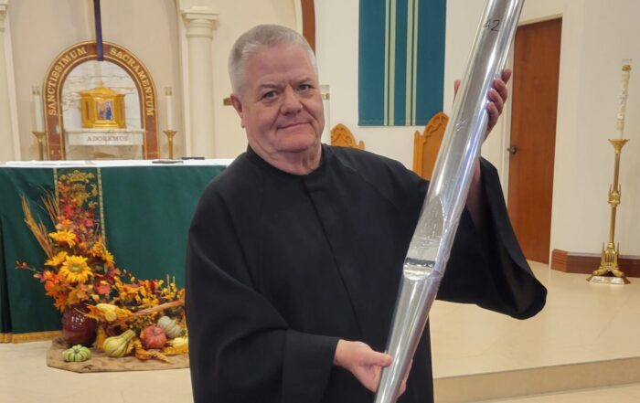 Fr Downey with an organ pipe at St Therese Catholic Church in Wellington FL