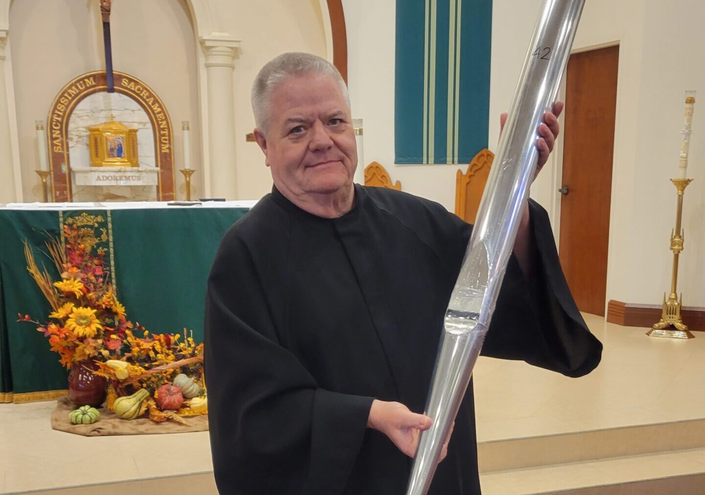Fr Downey with an organ pipe at St Therese Catholic Church in Wellington FL